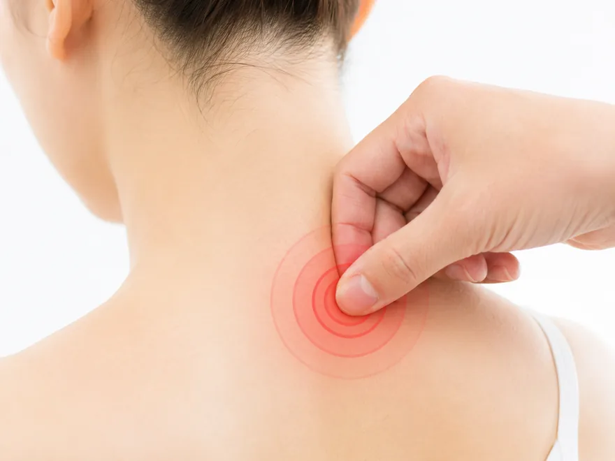 指で首の痛点を押さえ、痛みの原因を確認する様子